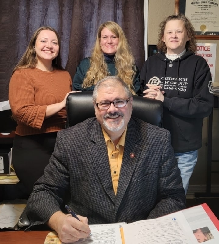 D. Todd Diederich at his desk with the staff of the Harrison, Michigan office